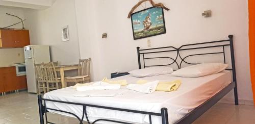 a bedroom with a bed with white sheets and yellow pillows at Perasma Apartments in Kypri