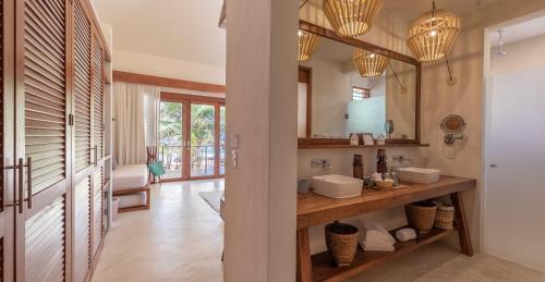 a bathroom with two sinks and a mirror at La Zebra Boutique Hotel in Tulum