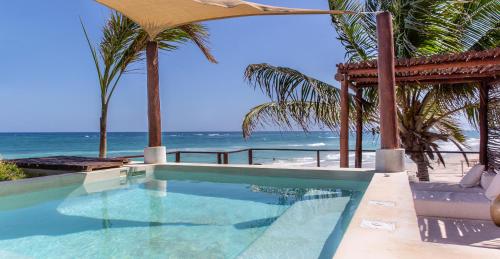 a swimming pool with the beach in the background at La Zebra Boutique Hotel in Tulum