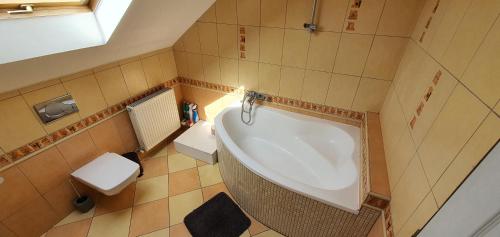 a small bathroom with a tub and a toilet at Apartmán Hrkovce 