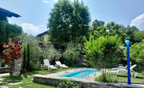 einen Pool in einem Garten mit weißen Stühlen und einem Pool in der Unterkunft Casa Unica- da Bruno in Colico