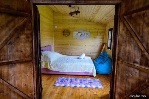 een kamer met een bed in een houten hut bij Kuca za odmor Oblutak in Lug