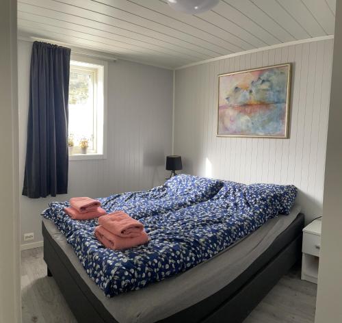 a bedroom with a bed with two towels on it at Luxurious cabin by the waterfront in Leknes