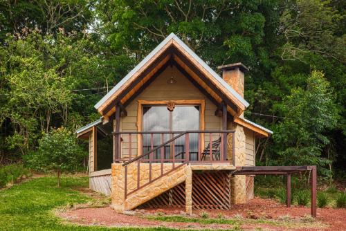 a small house with a balcony in a yard at Hotel & Spa Escondite de la Montaña in Sabana Redonda