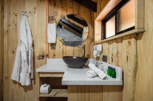 a bathroom with a bowl sink and a mirror at Hotel & Spa Escondite de la Montaña in Sabana Redonda