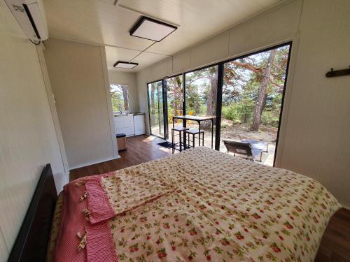 a bedroom with a bed and a large window at La calade in Bargème