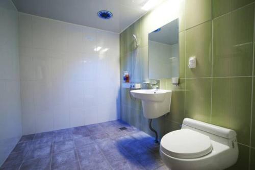 a bathroom with a white toilet and a sink at Seongsan Aqua Beach Hotel in Seogwipo