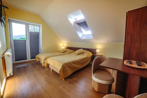 een slaapkamer met 2 bedden en een raam bij Villa ŁĄGI in Bukowiec