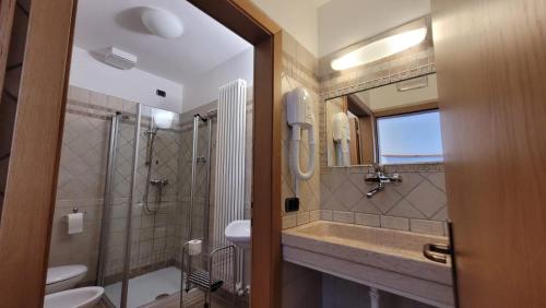 a bathroom with a sink and a shower and a mirror at RAINBOW in Rovereto