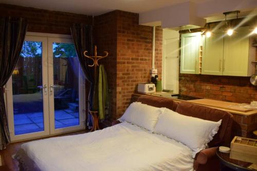 1 dormitorio con 1 cama y cocina con ventana en Rock Studio -Near City Centre-Free on street Parking-Free Wi-Fi, en Leeds