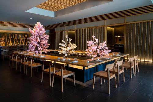 a long table in a room with pink flowers at Majestic Elegance Costa Mujeres - All Inclusive in Cancún