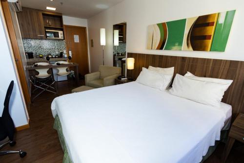 a hotel room with a large bed and a kitchen at Apartamento, Nobile Suítes Monumental , localização e conforto in Brasilia
