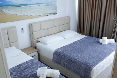 1 dormitorio con 2 camas y una foto del océano en Fishta apartments Q5 32, en Velipojë