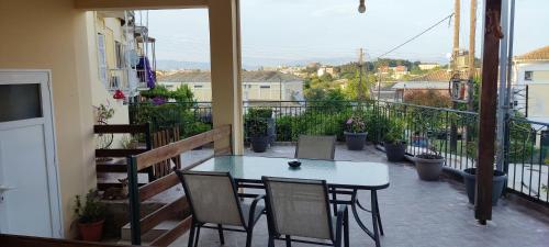 a patio with a table and chairs on a balcony at Silvia's Apartments in Corfu Town
