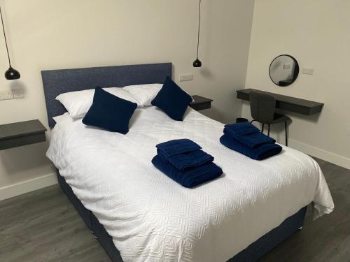 a bed with two blue towels on top of it at Ballymullock Barn Lofts in Carncastle