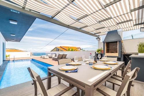 a dining room with a table and a swimming pool at Belle Maison by Homie in Funchal