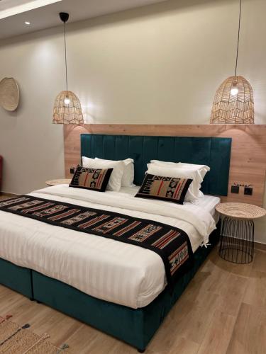 um quarto com uma cama grande e duas luzes pendentes em ريف سويت للأجنحة الفندقية em Abha