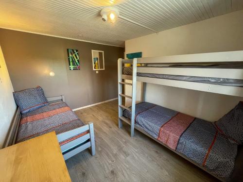 a room with two bunk beds and a table at Gite la Belle Iroise - Charmante maison de ville proche mer in Plouarzel