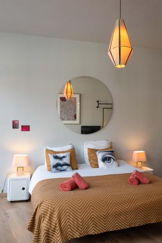 a bedroom with a large bed and a mirror at Belle de Nuit in Ostend