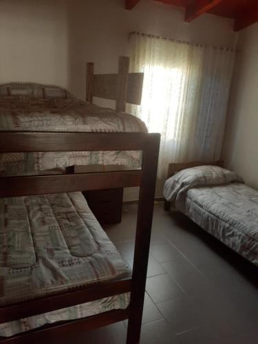 sypialnia z 2 łóżkami piętrowymi i oknem w obiekcie Casa Santa Elena w mieście Malargüe