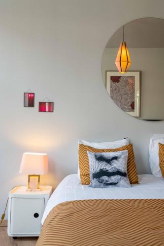 a bedroom with a bed with a mirror on the wall at Belle de Nuit in Ostend