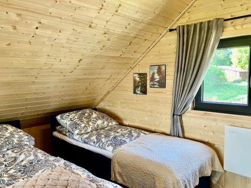 um quarto com duas camas num chalé de madeira em Słoneczne Mazury - Dom Wakacyjny em Piasutno