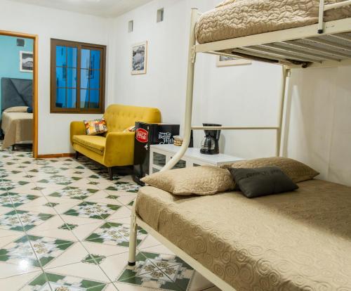 1 Schlafzimmer mit 2 Etagenbetten und einem gelben Stuhl in der Unterkunft Atitlan´s House in Panajachel