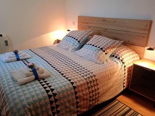 1 dormitorio con 1 cama grande y toallas. en Acogedor Apartamento Ocaña, en Ocaña