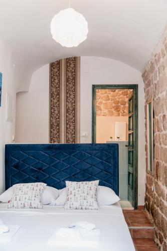 a bed with a blue headboard in a room at Lito Apartments Sibenik in Šibenik