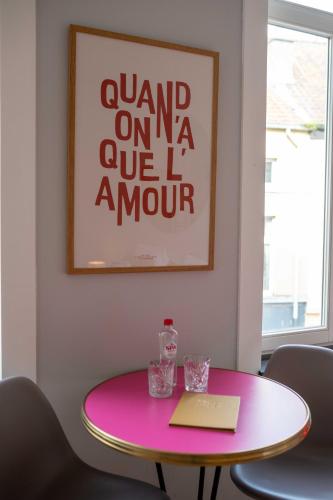 a pink table with two chairs and a picture at Belle de Nuit in Ostend