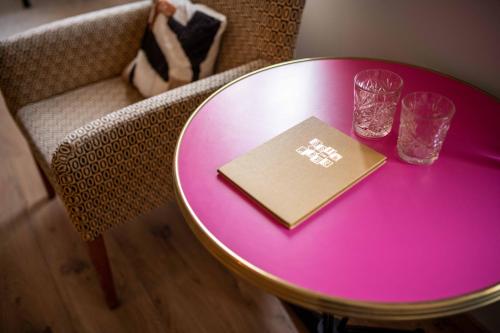 a purple table with a book and glasses on a chair at Belle de Nuit in Ostend