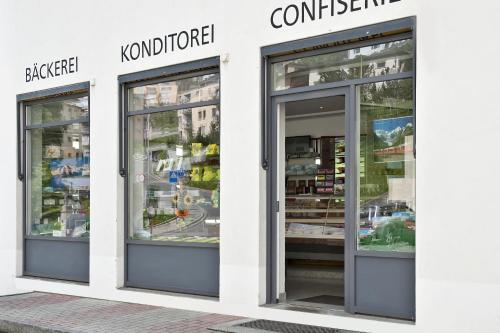 a store with three glass doors on a building at Laagers Hotel Garni in Samedan