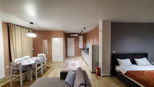 Sirius Apartment في شكودر: غرفة نوم بسرير ومطبخ وغرفة طعام