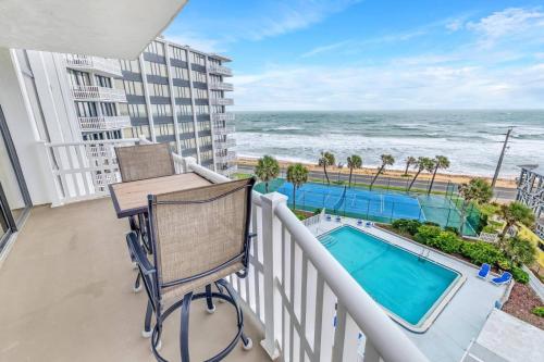 a balcony with a table and chairs and the ocean at Nautilus Condo 608 | S Ocean Shore | Flagler Beach in Flagler Beach