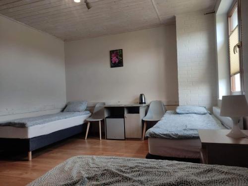 a room with two beds and a table in it at AsPa in Ostrowo