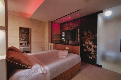 a bedroom with a large bed and a television at Euphoria Resort in Olgiata
