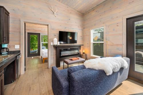 a living room with a blue couch and a fireplace at Asheville River Cabins in Arden