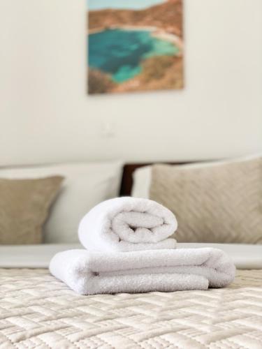 una pila de toallas sentadas encima de una cama en Acta's Rooms, en Himare