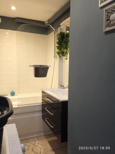 une salle de bain avec un lavabo et une baignoire dans l'établissement Comme à la maison, à Calais