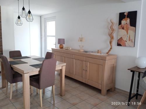 une salle à manger avec une table et une armoire dans l'établissement Comme à la maison, à Calais