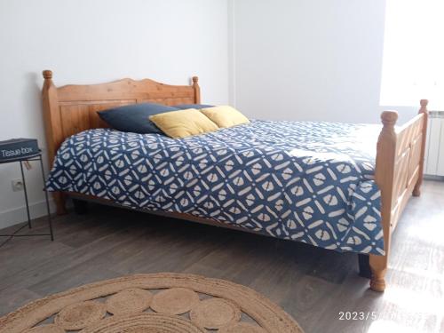 une chambre avec un lit avec une couette bleue et blanche dans l'établissement Comme à la maison, à Calais