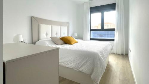 een witte slaapkamer met een groot bed en een raam bij Apartamento Málaga Beach, 2A in Málaga