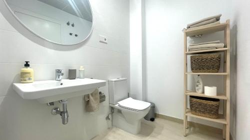 een badkamer met een wastafel, een toilet en een spiegel bij Apartamento Málaga Beach, 2A in Málaga