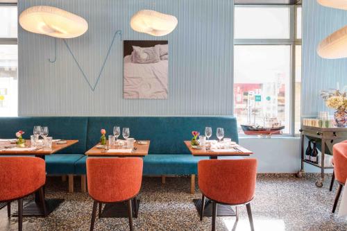 a dining room with two tables and a blue couch at Belle de Nuit in Ostend