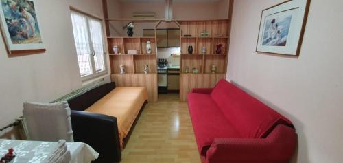 a living room with two red chairs and a couch at Aleksinac Centar Two-Bedroom Apartment in Aleksinac