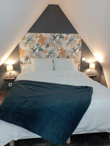 une chambre avec un grand lit avec une grande tête de lit dans l'établissement Gîte avec son bain nordique privatif au feu de bois, à Pleubian