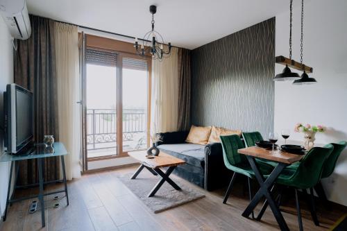 a living room with a bed and a table and a dining room at Vrnjačka Promenada - Pešačka zona - Baby friendly in Vrnjačka Banja