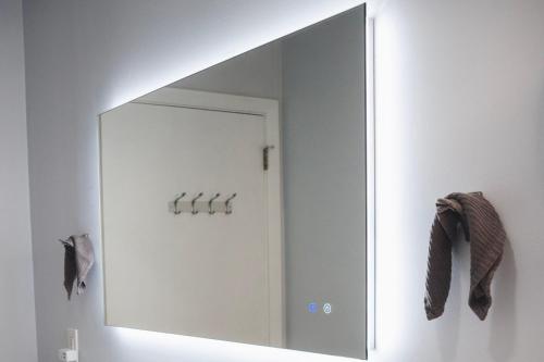 a mirror on a wall in a room at Cozy Oasis: Luxury & Modern Apartment By Revere Beach in Revere