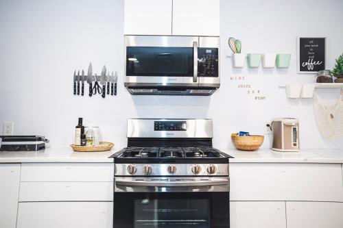 a kitchen with a stove and a microwave at Cozy Oasis: Luxury & Modern Apartment By Revere Beach in Revere