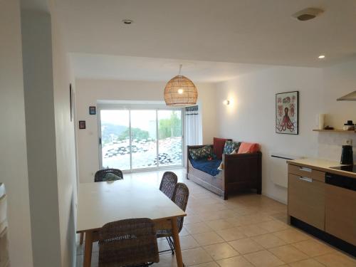 uma cozinha e sala de estar com uma mesa e um sofá em Virage 9 3/4 em Saint-Mandrier-sur-Mer